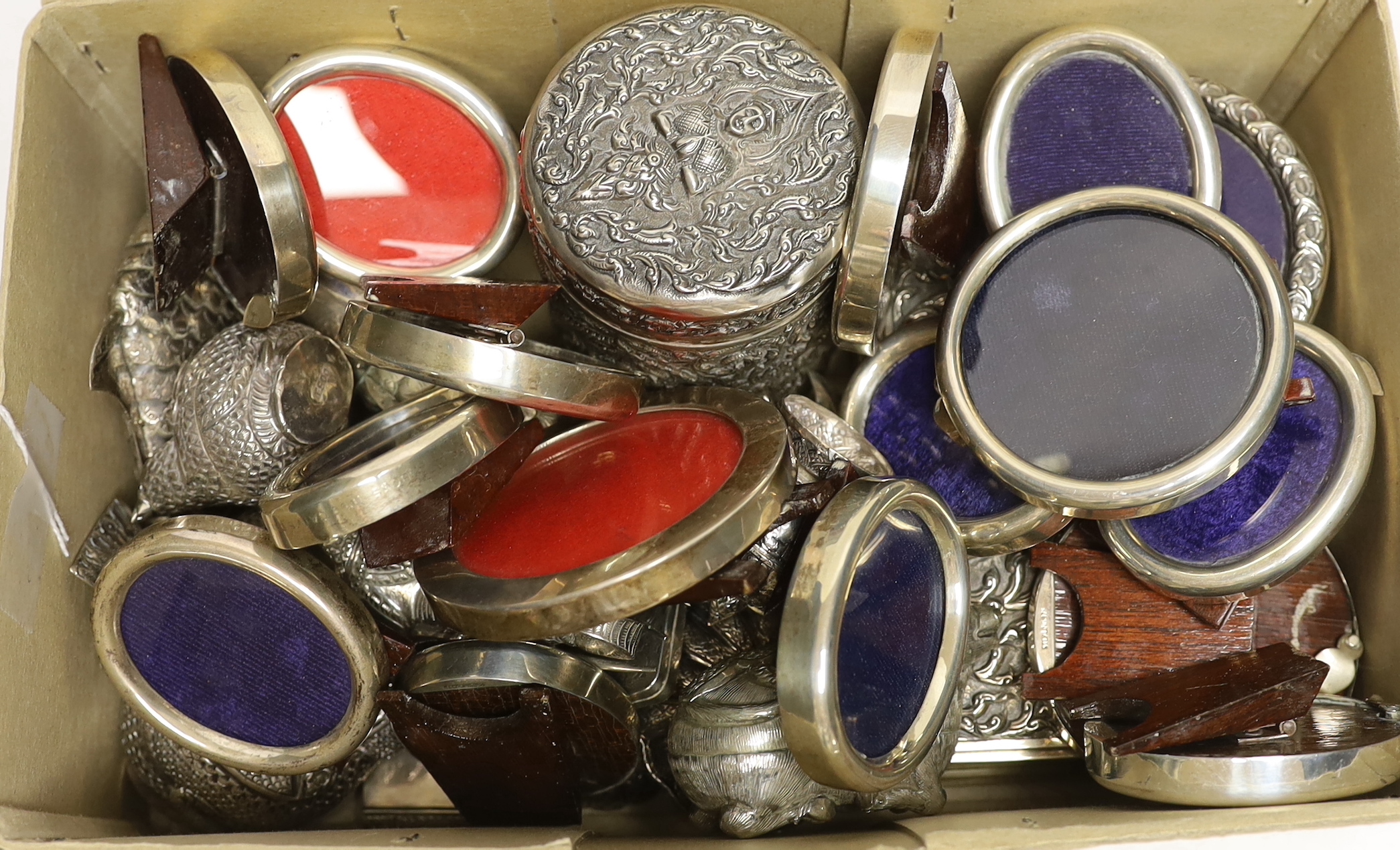 Sixteen assorted sterling mounted small photograph frames, largest 88mm and a quantity of assorted Thai boxes, mainly modelled as birds and other animals, a Thai repousse sterling cannister and cover and a Thai sterling